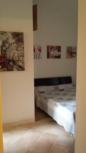 sypialnia z łóżkiem i obrazami na ścianie w obiekcie Appartamento Colletta w mieście Ventimiglia