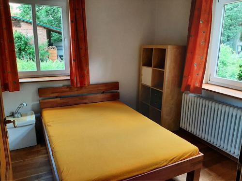 um quarto com uma cama num quarto com duas janelas em Ferienwohnung Bioland-Hof Wilkens em Visselhövede