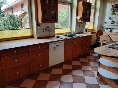 uma cozinha com armários de madeira, um lavatório e uma mesa em Ferienwohnung Bioland-Hof Wilkens em Visselhövede