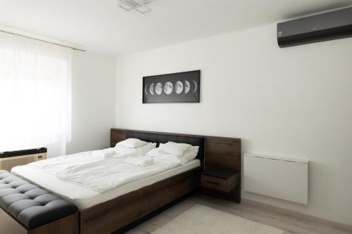 um quarto com uma cama grande e lençóis brancos em Smart Square with free parking em Debrecen