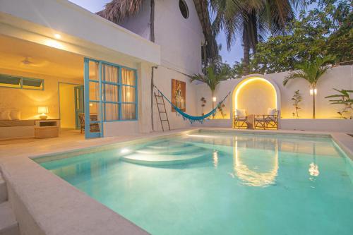 a swimming pool in front of a house at Hotel Fenix Beach Cartagena in Tierra Bomba