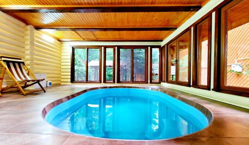 a pool in the middle of a room with windows at Gostynniy Dvir in Forest Коттеджи in Migovo
