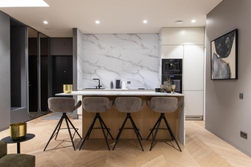 a kitchen with a marble counter and stools at HOUSE38 Panoramic View Apartments SELF CHECK-IN in Kaunas