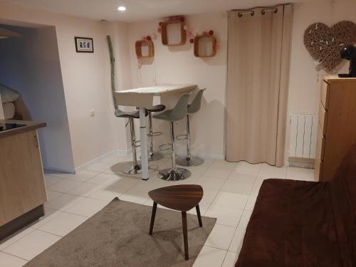 a kitchen with a sink and a stool in a room at Appartement cosy avec terrasse privée et parking in Horbourg