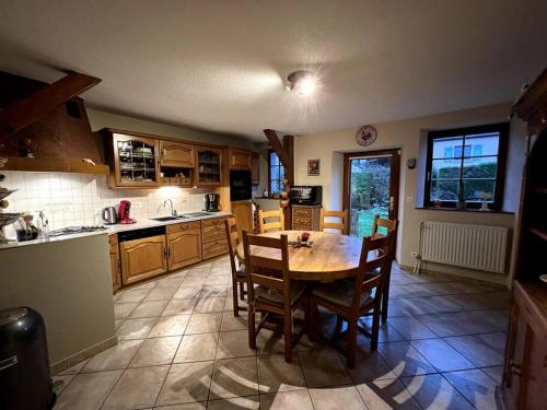 une cuisine avec une table et des chaises dans une pièce dans l'établissement Gîte La maison de Jules, à Muntzenheim