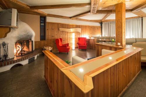 a large living room with a fireplace and red chairs at T3 Gasthof Spullersee in Wald am Arlberg