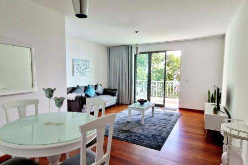 uma sala de estar com uma mesa de vidro e um sofá em Ocean Pearl Apartment X no Funchal