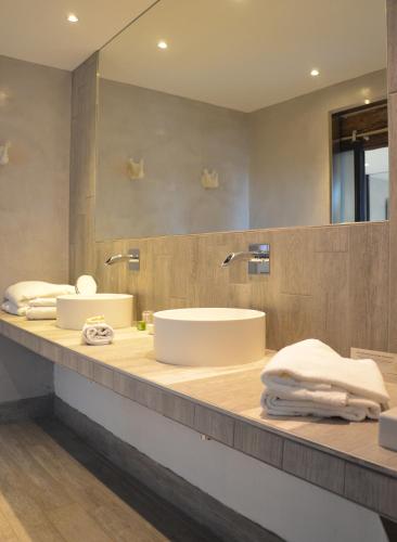 a bathroom with two sinks and a mirror at Logis Hôtel restaurant des Pins in Bédoin