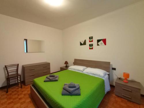 Un dormitorio con una cama verde y una silla. en Casa Criss, en Lovere