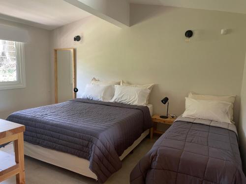 a bedroom with two beds and a window at La Franca Aparts in Villa General Belgrano