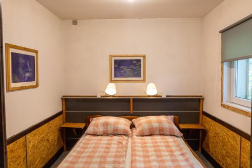 a bedroom with a bed and two lamps on the wall at Apartmani Papeš in Krapina