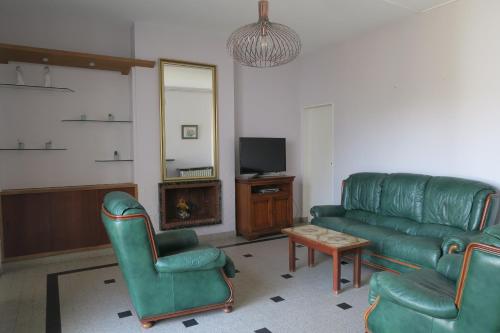 a living room with a couch and chairs and a tv at Chez Carmen in Albi