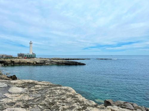 a lighthouse on a rocky island in the water at La Petite Maison in Augusta