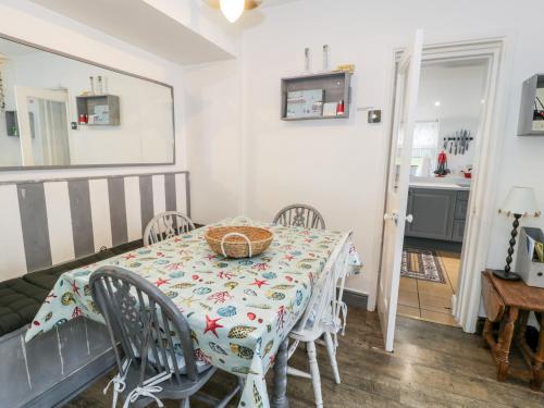 a dining room with a table and chairs at Sibrwd Y Mor in Harlech