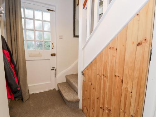 a stairway with a wooden door leading to a room at Sibrwd Y Mor in Harlech