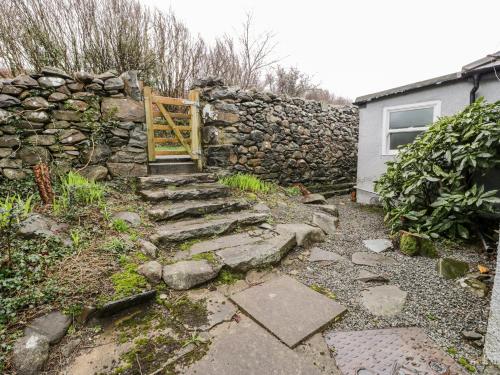 a stone wall with a gate and a stone stairs at Sibrwd Y Mor in Harlech