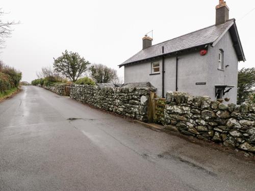 a stone wall next to a stone house at Sibrwd Y Mor in Harlech