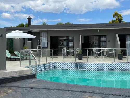 a house with a swimming pool in front of a house at INBLOEM in Bloemfontein