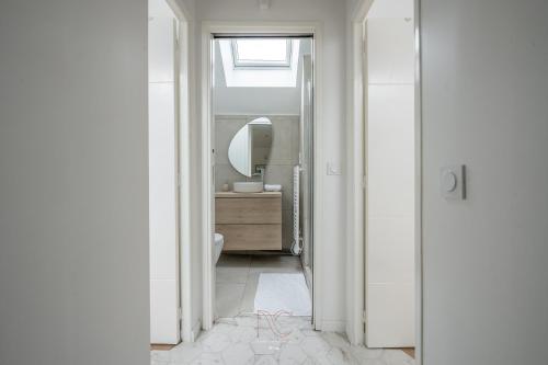 La salle de bains blanche est pourvue d'un lavabo et d'un miroir. dans l'établissement *Disneyland-Paris à 15 min* 7pers, Wifi, Netflix, à Quincy-Voisins