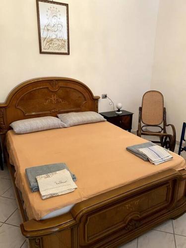 a bedroom with a wooden bed with two towels on it at Domus Sici in Pompei