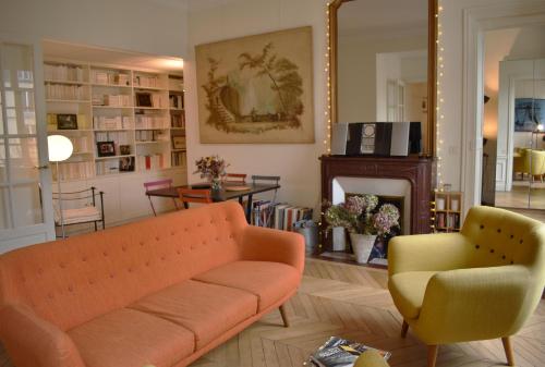 - un salon avec un canapé orange et une chaise jaune dans l'établissement Parc Monceau, à Paris