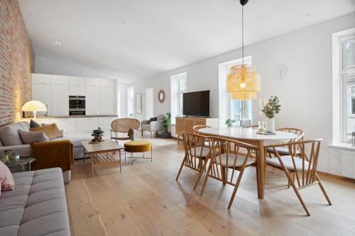 a living room with a table and chairs and a couch at Central 3-bedroom apartment with huge terrace, including queen size beds in Aalborg