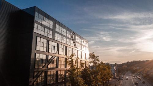 een hoog glazen gebouw met een straat ervoor bij HOUSE38 Panoramic View Apartments SELF CHECK-IN in Kaunas