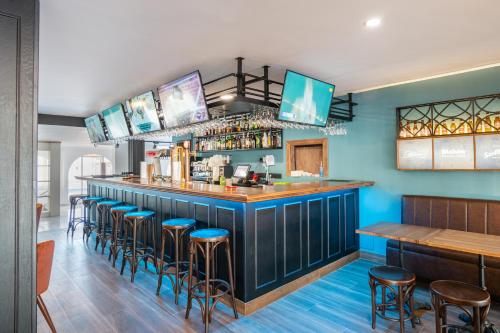 a bar in a restaurant with blue walls and stools at Hotel Nerja Club Spa by Dorobe in Nerja