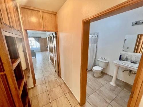 a bathroom with a toilet and a sink at Apartamentos Villas del Sol in San Pedro Sula