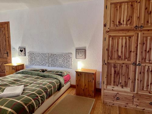 um quarto com uma cama e um armário de madeira em La Baita di BessenHaut 