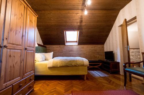 ein Schlafzimmer mit einem Bett und einer Holzwand in der Unterkunft Vándor Fogadó in Gyöngyössolymos