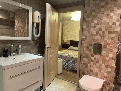 ein Bad mit einem Waschbecken und einem WC sowie ein Schlafzimmer in der Unterkunft Brand New Valera Luxury Studio in Warna