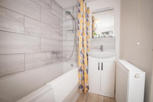 y baño con bañera, lavamanos y ducha. en Immaculate Apartment meters from the beach en Great Yarmouth