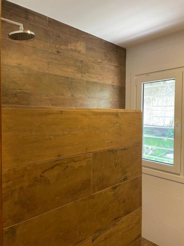 a large wooden wall in a room with a window at La Franca Aparts in Villa General Belgrano