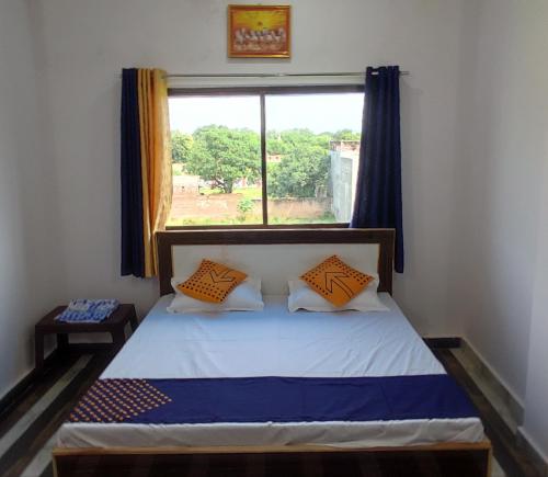 a bedroom with a bed with a window at Kashi Nest Homestay in Varanasi