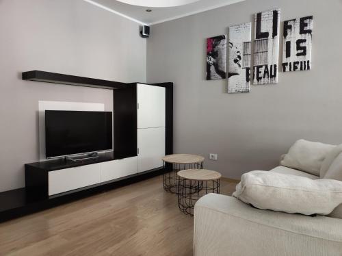 uma sala de estar com um sofá e uma televisão de ecrã plano em qu4ttro em Riva del Garda