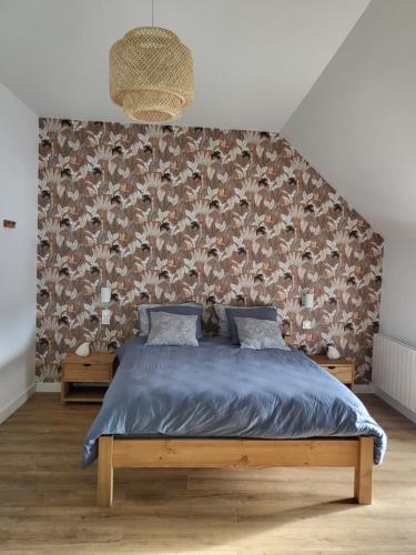 um quarto com uma cama com um edredão azul em Charmante maison près du canal em Tinténiac