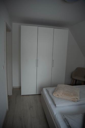 a bedroom with white cabinets and a bed at Ferienhaus Sehmatal in Sehmatal
