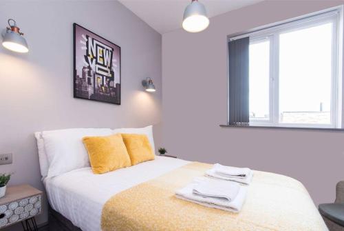 a bedroom with a bed with a yellow blanket and a window at Impressive Apartment in Derby in Derby