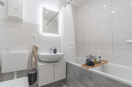 a white bathroom with a sink and a tub at Apartment Wesseling in Wesseling