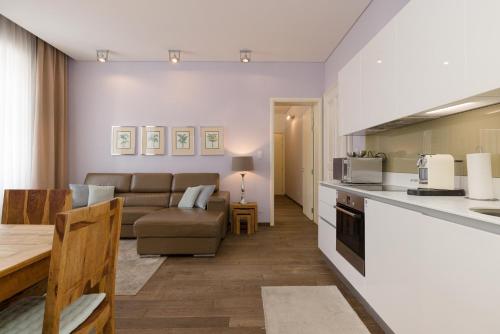 uma cozinha e sala de estar com um sofá e uma mesa em Rafael Kaiser Premium Apartments - Contactless 24h Check-In em Viena