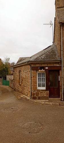 a brick building with a window and a door at gite du pré in Gorron