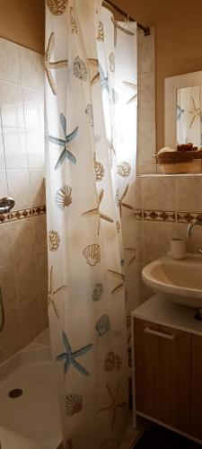 a bathroom with a shower curtain with fish on it at gite du pré in Gorron