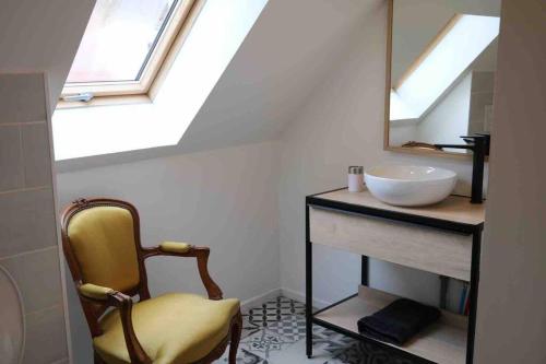a bathroom with a sink and a mirror and a chair at Maison Céleste in Nuits-Saint-Georges