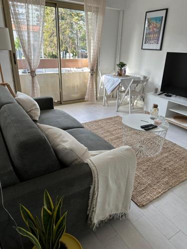 un salon avec un canapé et une table dans l'établissement Spacieux studio à Golfe Juan 2 minutes des plages, à Vallauris