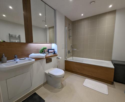 a bathroom with a sink and a toilet and a tub at Luxury One Bedroom Flat in Deptford in London