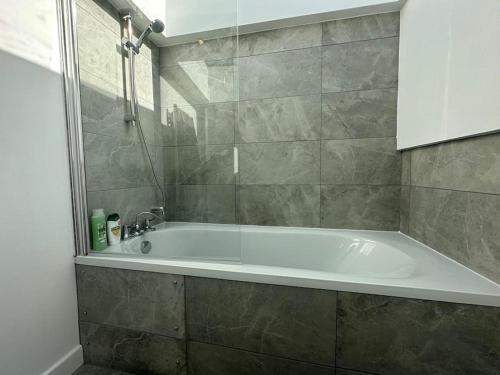 a bathroom with a white tub and a shower at Lovely New Decor Studio - 4 The Southwell in London