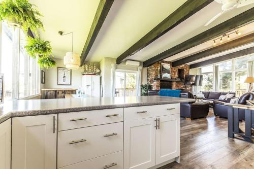 a kitchen with white cabinets and a living room at Mountain View-Backyard-Air-Conditioning-BBQ-15mins walk Blue Mountain Village in Blue Mountains