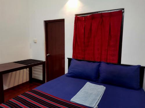 um quarto com uma cama com uma cortina vermelha por cima em Nallur Holidays Inn em Jaffna