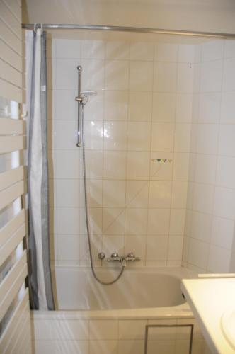 een badkamer met een douche en een bad bij Scorpio 0702 in Nieuwpoort